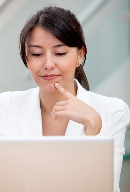 Thoughtful business woman working on a laptop