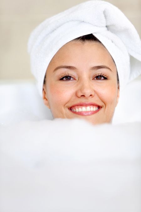 Woman taking a bath with a towel on her head - beauty concepts