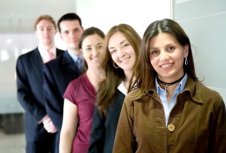 business team in an office all smiling and standing in a row