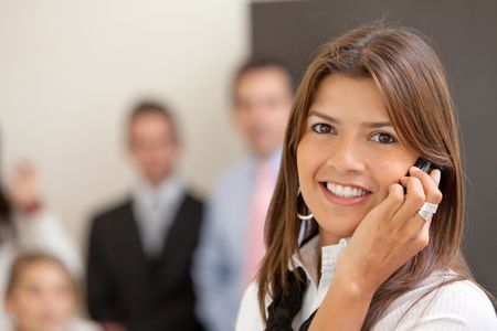 Business woman smiling and talking on the phone at the office