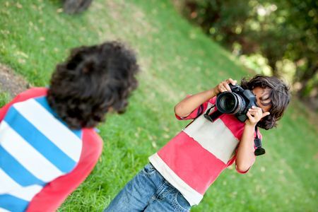 Boy playing with a camera at the park