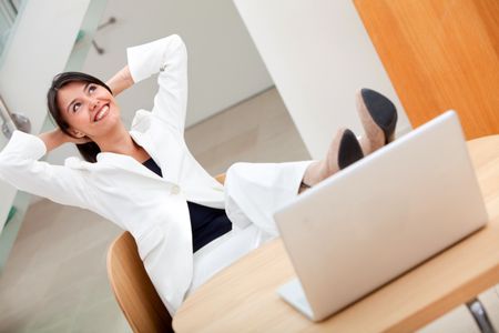 Successful business woman at the office with her feet on the desk