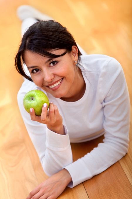 Healthy eating woman holding an apple and smiling