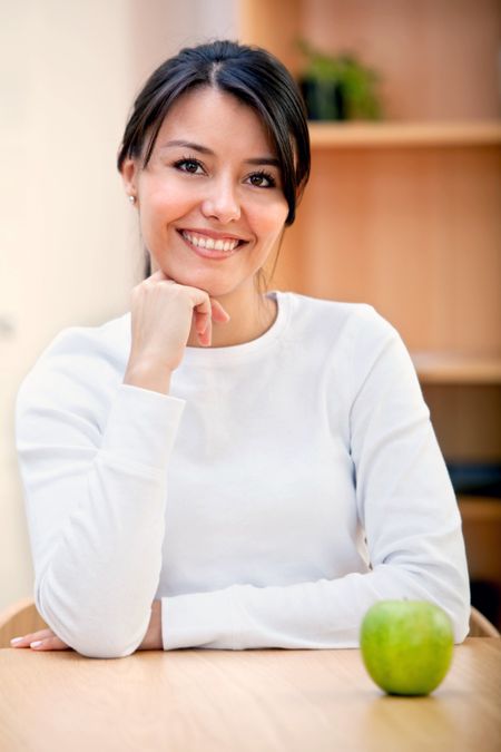 Healthy eating woman with a green apple and smiling