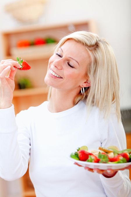Healthy eating woman with a fruit salad and smiling