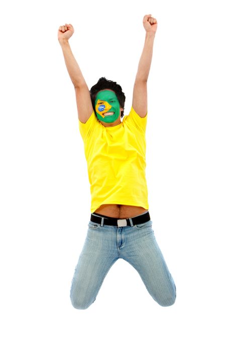 Happy brazilian fan with the flag painted on his face jumping