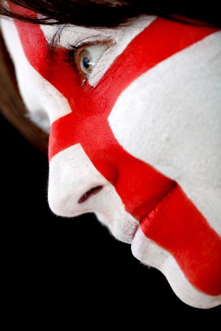 Portrait of a woman with the english flag painted on her face - over a black background