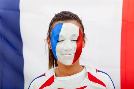 Portrait of a woman with the french flag painted on her face