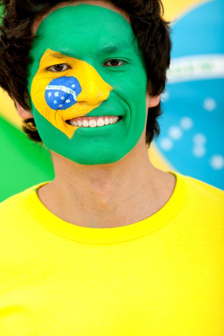 Portrait of a man with the Brazilian flag painted on his face