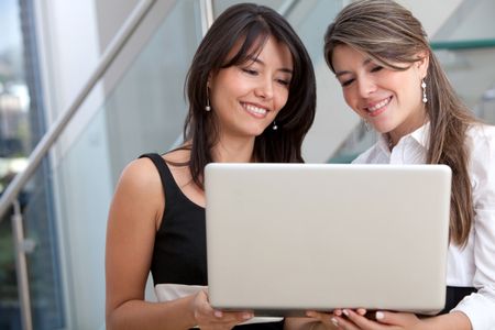 Business women with a laptop at the office and smiling