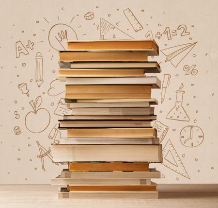 A pile of books on table with school hand drawn doodle sketches and symbols
