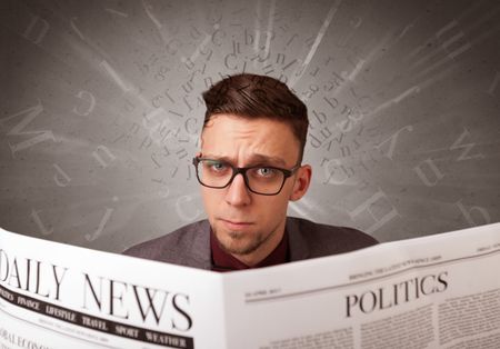 Young smart businessman reading daily newspaper with alphabet letters above his head