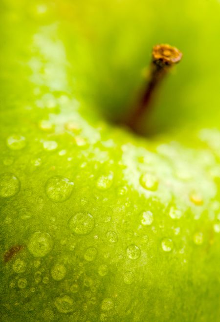 apple in green with water drops on its surface