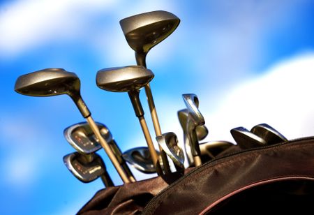 golf clubs in a bag over a beautiful blue sky in the background