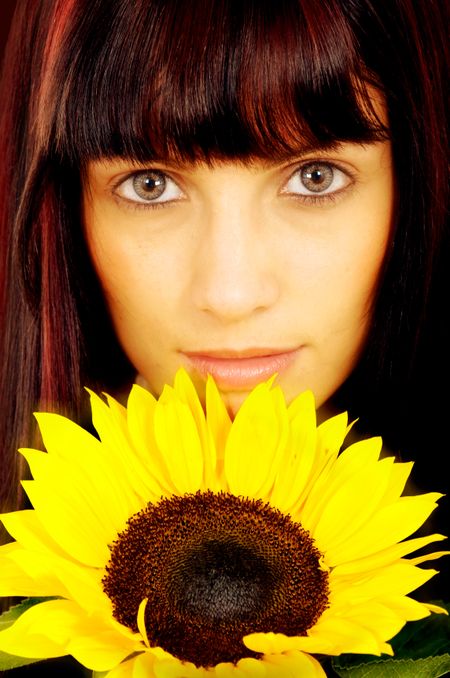 fashion woman portrait with a beautiful yellow sunflower flower by her face