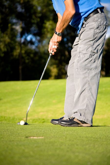 male golfer about to shot in a putting green near the hole