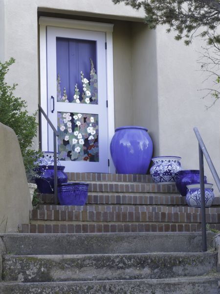 Outdoor stairway with blue pottery to decorated door of house