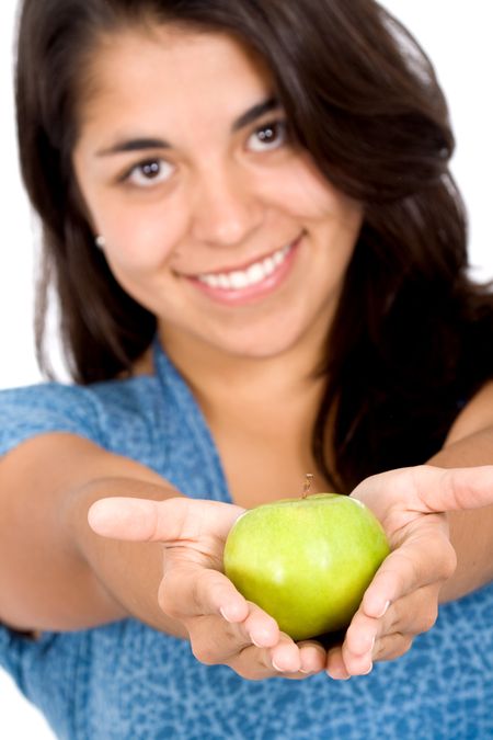 girl offering a green apple smiling over a white background