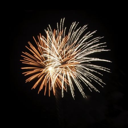 Two bursts of fireworks inside each other, one white, one reddish-orange with white-hot core