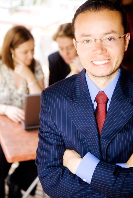 business man portrait with his colleagues working in the background
