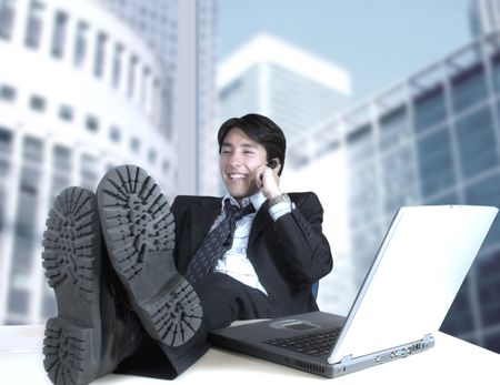 business man in his office talking on the phone with a corporate view through the window