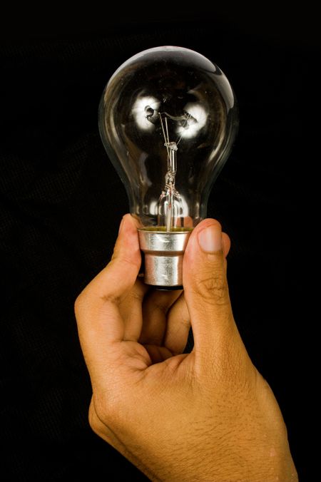 hand holding a bulb over a black background