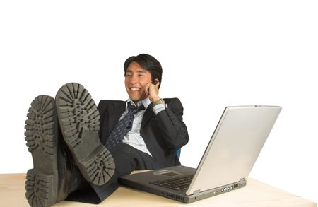 business man relaxing on his desk whilst talking on the phone