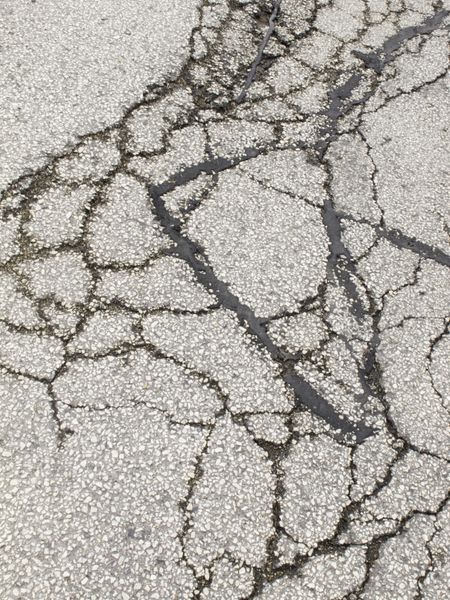 Cracked asphalt pavement in parking lot
