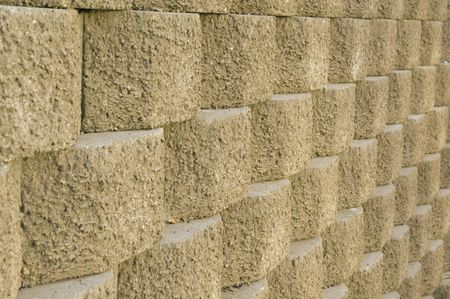 Retaining wall of rounded blocks with rough texture, partial view, daylight