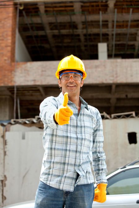 Construction worker with thumbs up at a building site