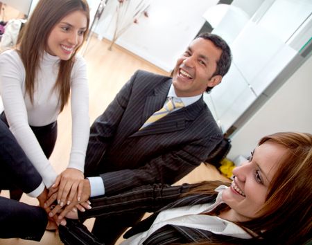 business people in an office with hands together - teamwork concepts