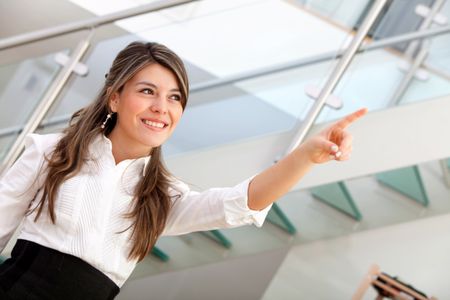 Business woman pointing at something at the office