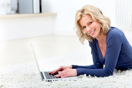 Woman lying on the floor working on a laptop computer