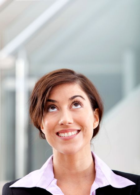 Pensive business woman smiling at the office