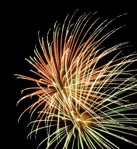 Two bursts of yellowish fireworks with intermingled streaks