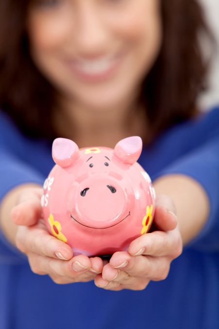 Woman holding a piggy bank in her hands and smiling