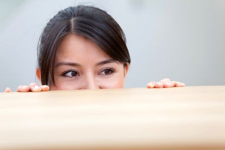 Woman looking over a wooden table indoors