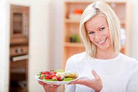 Healthy eating woman holding a fruit's tray and smiling