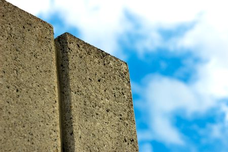 Concrete wall beneath clouds in a blue sky