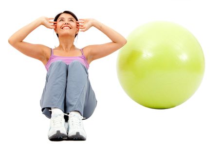 Fit woman exercising with a pilates ball - isolated over a white background