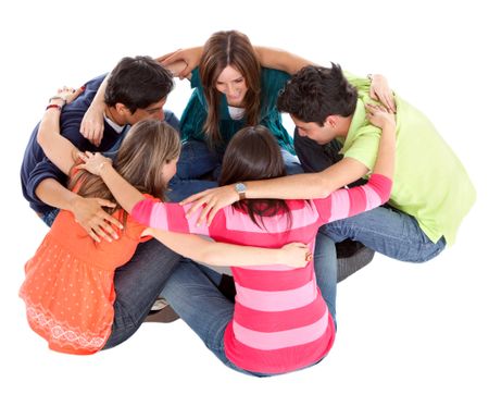 Group of friends sitting on the floor and hugging - isolated over a white background