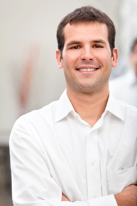 Handsome business man portrait smiling at the office