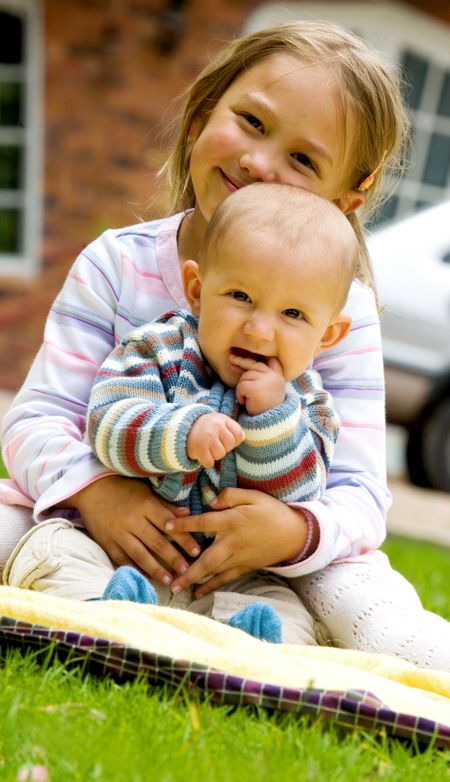 cute brother and sister protrait outdoors - family together