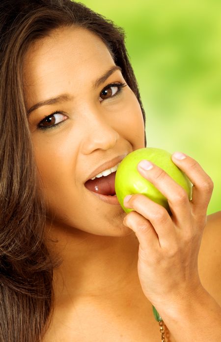 beautiful latin american girl eating an apple outdoors