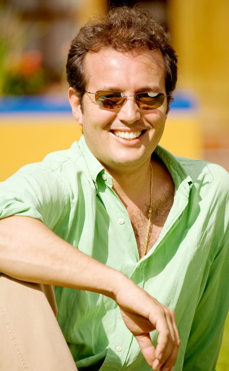 casual man portrait looking very relaxed outdoors wearing sunglasses