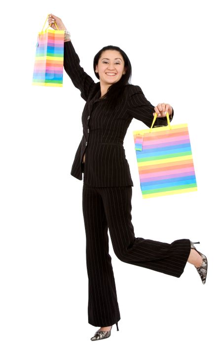 happy girl smiling holding shopping bags - isolated over a white background