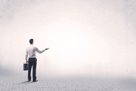 Serious business man standing on grey brick floor and thinging about decisions concept