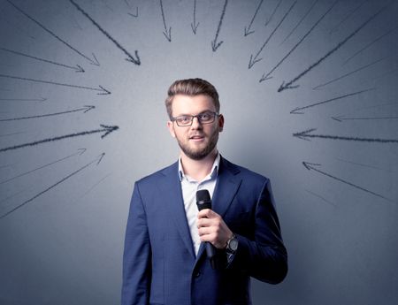 Businessman speaking into microphone with arrows pointing towards his head