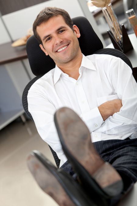 Confident business man at the office with his feet on the desk