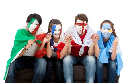 Patriotic group of people from different countries and flags painted on their faces watching television